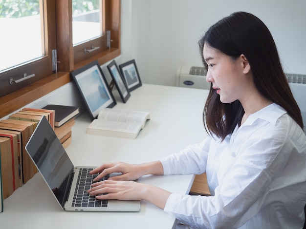 Young asian woman working with computer in room