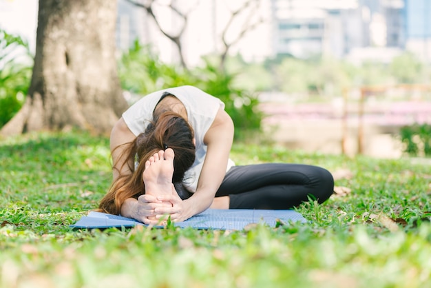 Young asian woman yoga outdoors keep calm and meditates while practicing yoga