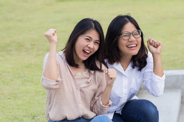 手をつないで笑顔の女性と若いアジアの女性の友情の概念