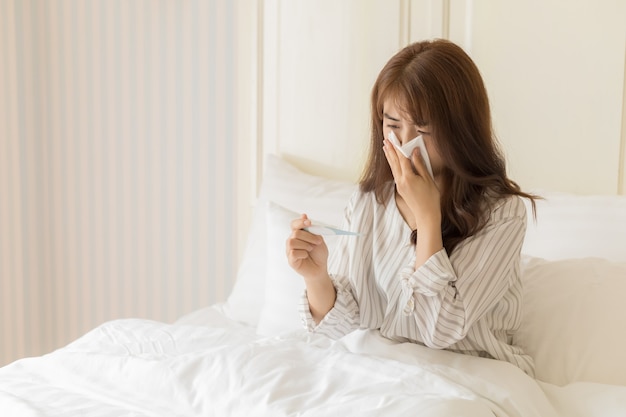 若いアジアの女性は風邪をひいています。健康と病人の概念。