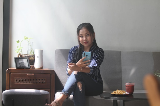 YOUNG ASIAN WOMEN RELAXING READING AND DRINKING COFFEE IN CAFE