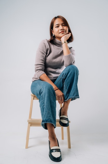 Giovani donne asiatiche con camicia lunga e jeans nel concetto di moda studio su sfondo bianco