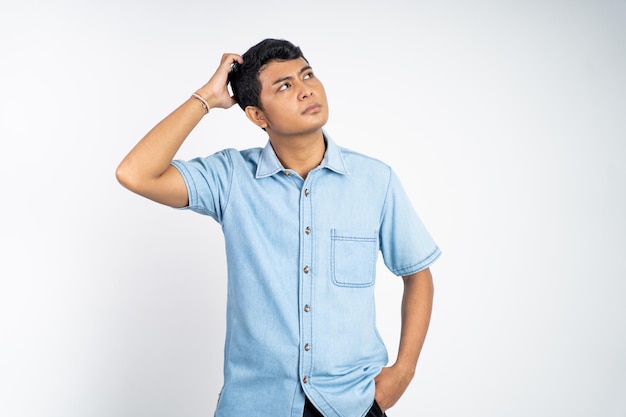 Photo young asians hold their heads when thinking on an isolated background