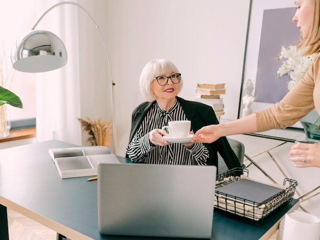 young assistant brought a coffee to the boss in office