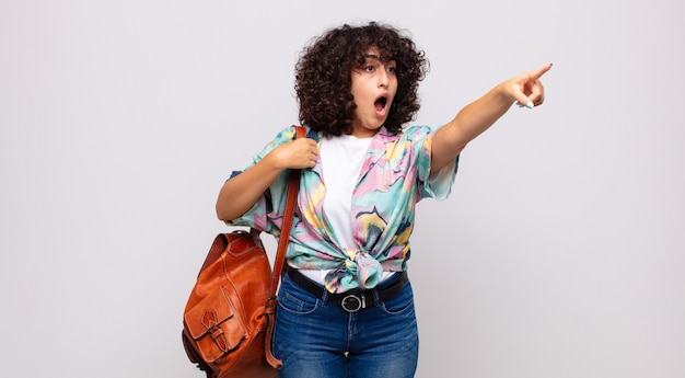 young astonished woman with a colorful shirt and a backpack