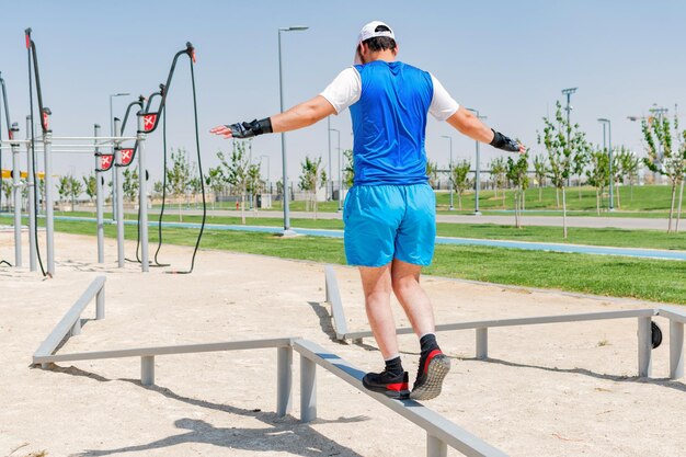 Young athlete balancing exercise walking on bars on a training field