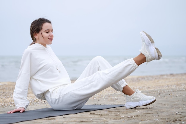 Young athlete doing her morning exercises at the beach High quality photo