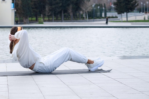 Young athlete doing situps on mat at the park High quality photo