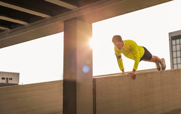 Photo young athlete exercising push ups on parking level