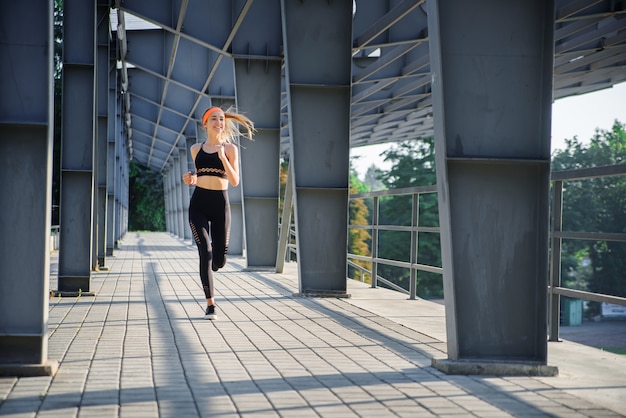 Young athlete is running near the stadium.