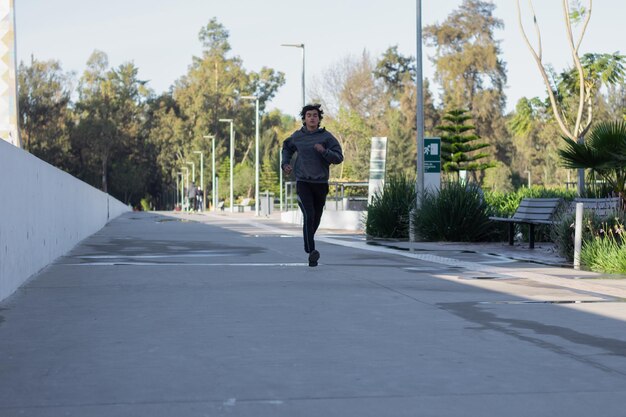 Young athlete jogging in the outdoor park in the morning among nature