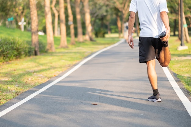 Giovane atleta che streching nel parco all'aperto.