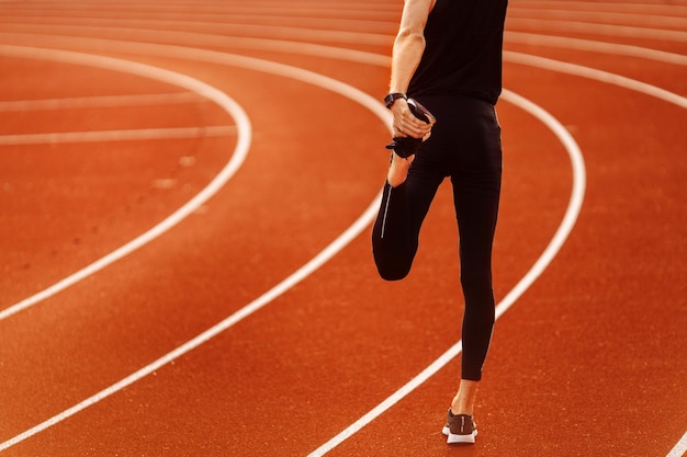 Young athlete resting after running in the stadium at summer