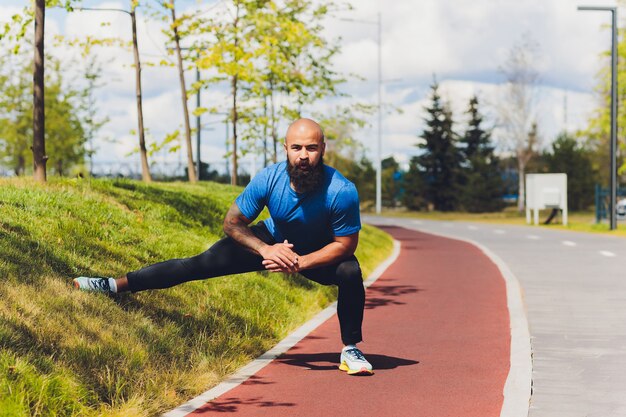 Young athlete running fast outdoors. Wearing sport cloth, doing wide step, demonstrating healthy way of life, wide shot.