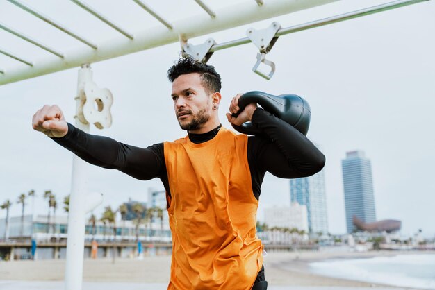 Young athlete training in the morning on the beach at the gym