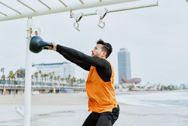 Young athlete training in the morning on the beach at the gym