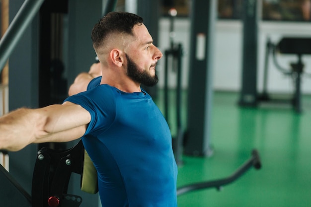 A young athlete trains in the gym Bodybuilder trains the muscules of the chest