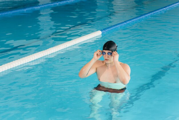 Юный спортсмен тренируется и готовится к соревнованиям по плаванию в бассейне. Здоровый образ жизни.