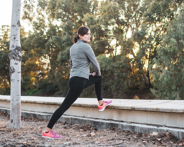 Young athlete woman doing stretching in the park