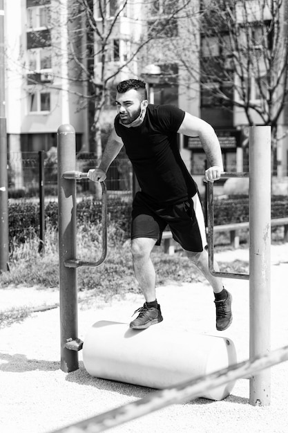 Young Athlete Working Out Triceps In An Outdoor Gym Doing Street Workout Exercises