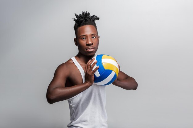 Young athletic African-American man with volleyball ball