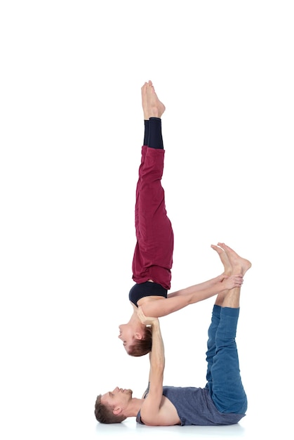 Young athletic couple practicing acroyoga Balancing in pair