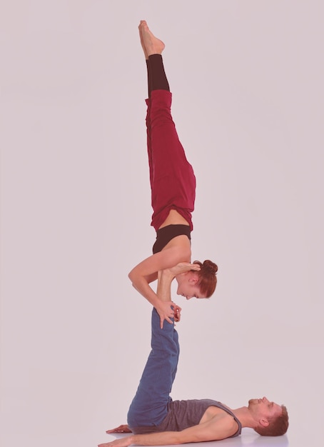 Young athletic couple practicing acroyoga Balancing in pair