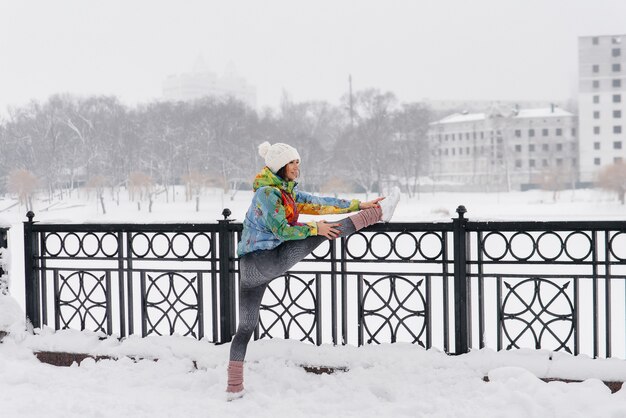 A young athletic girl is warming up before running on a frosty day. Fitness, running.