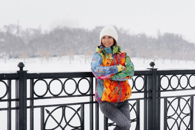 A young athletic girl poses on a frosty and snowy day. Fitness, running