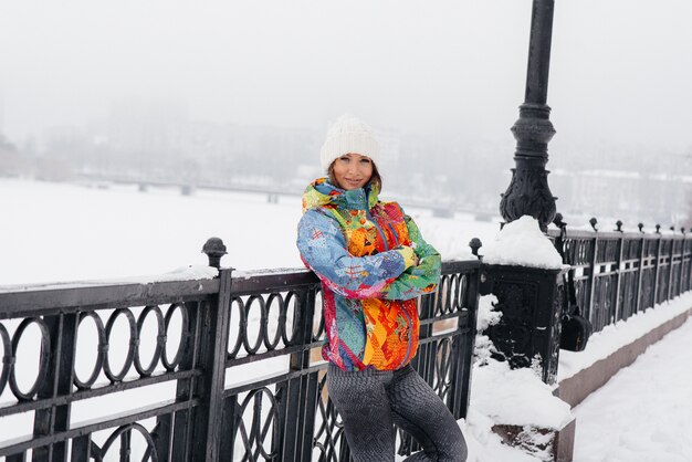 A young athletic girl poses on a frosty and snowy day. Fitness, running