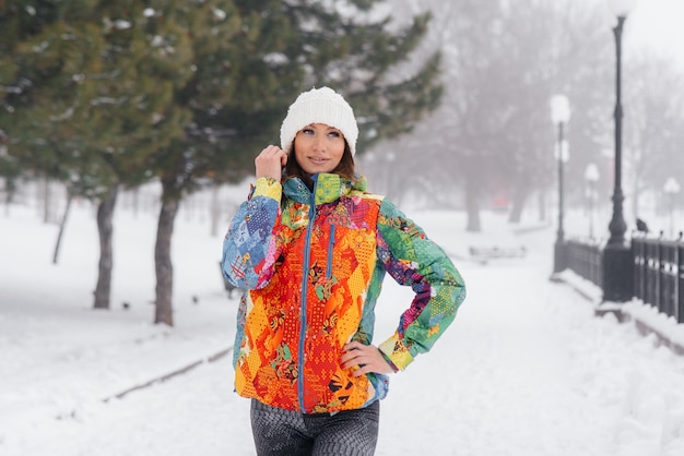 A young athletic girl poses on a frosty and snowy day. Fitness, running.