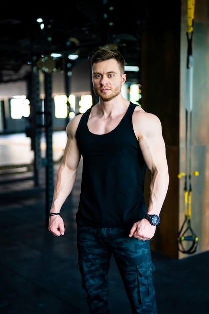 Young athletic man in the gym Strong gym coach standing