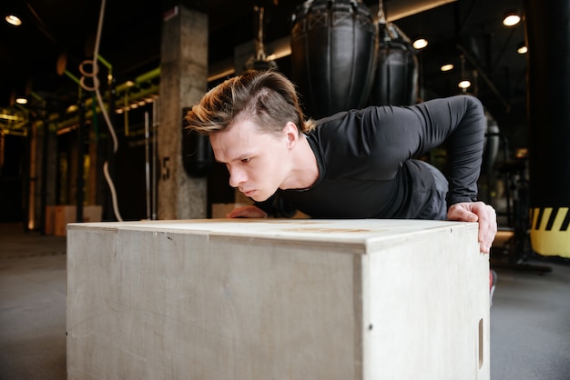 Young Athletic man push-ups on box