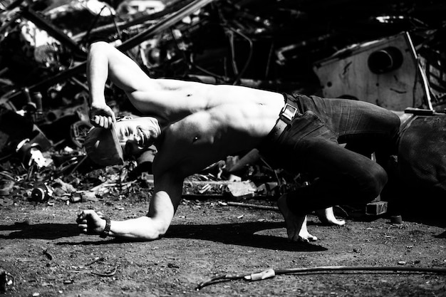 Young Athletic Man Stretch at Industrial Junkyard