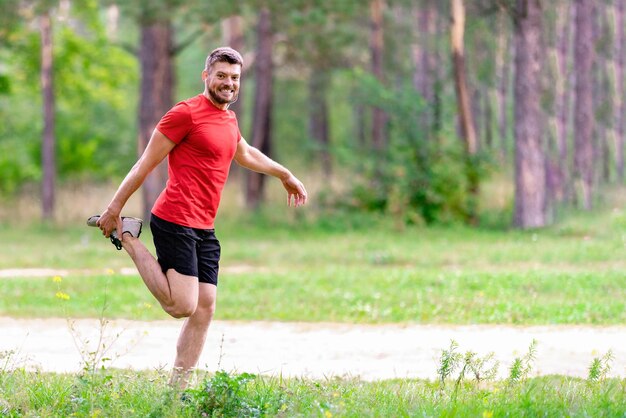 屋外でストレッチする若い運動選手