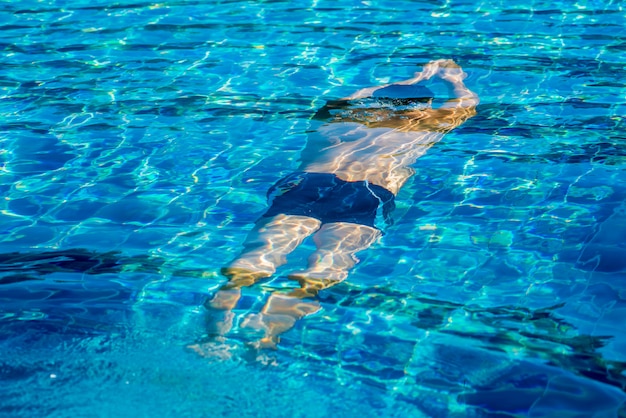 Young athletic man swimming in the swimming pool