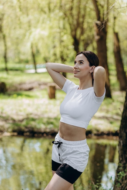 Young athletic woman doing longitudinal splits outdoors Girl go in for sports healthy lifestyle athletic body She is in sportswear black top and shorts Sport concept