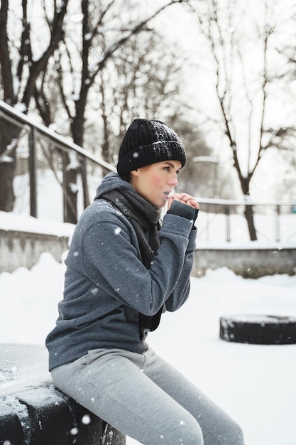 Young athletic woman during her outdoors winter workout with a tire