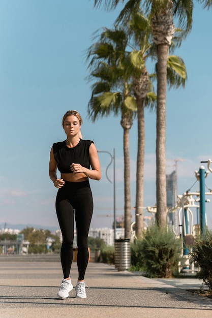 Young athletic woman is running during her summer jogging workout