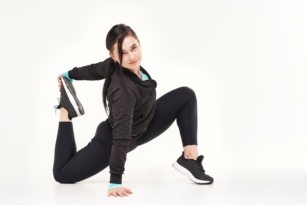 Young athletic woman making yoga and gymnastics stretching exercises isolated on white