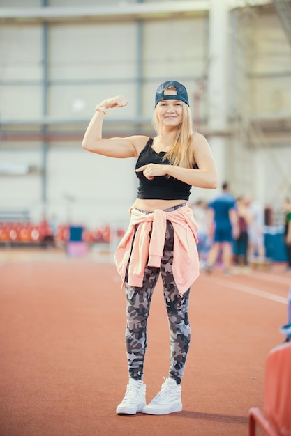 Young athletic woman showing her muscles posing