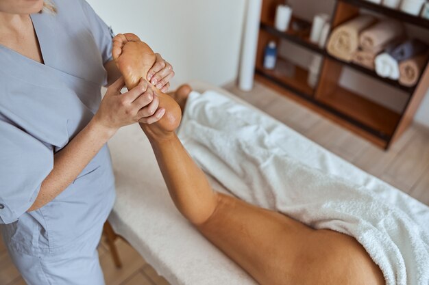 Foto la giovane donna attraente nel salone di massaggio sta avendo procedure di bellezza e sanitarie