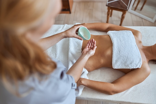 Foto la giovane donna attraente nel salone di massaggio sta avendo procedure di bellezza e sanitarie