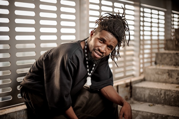 Young and attractive african american man sitting near the window