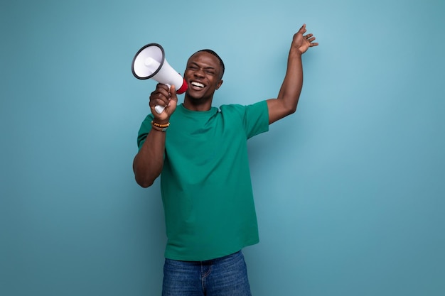 Photo young attractive african man dressed in a basic tshirt holding a loudspeaker to attract attention