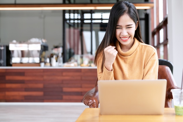 Young attractive asian female student using laptop compute