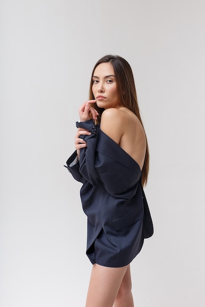 Young attractive asian woman in blue suit isolated on grey studio background