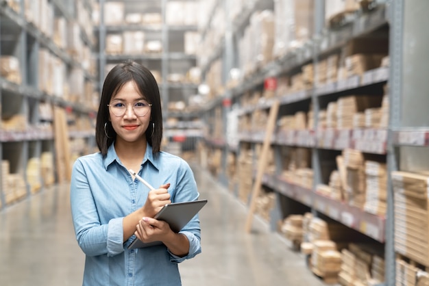 Young attractive asian worker, owner, entrepreneur woman holding smart tablet looking at camera.