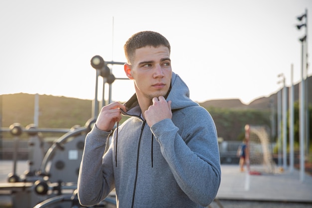 A young attractive athlete in the sports park looks to the side, concept of youth and sport