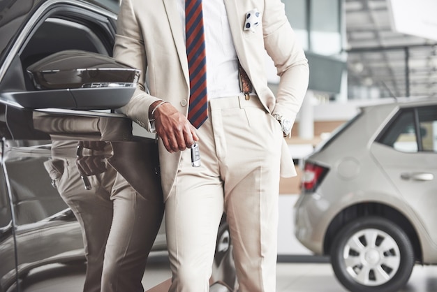 The young attractive black businessman buys a new car, dreams come true.